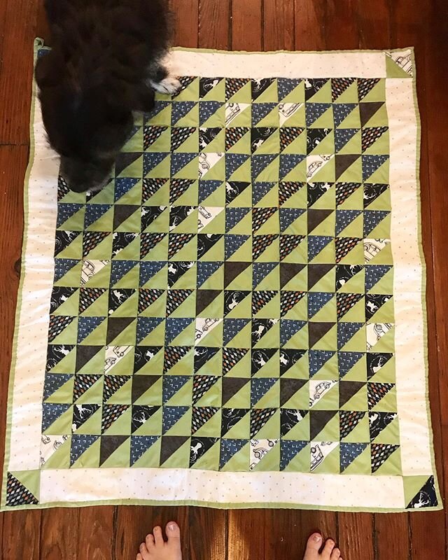 Quilt, feet, and a blurry dog. Waiting for the arrival of the new nephew.  #quilt #dog #fabric #pattern #triangles #quilting #quiltblock #babyblanket