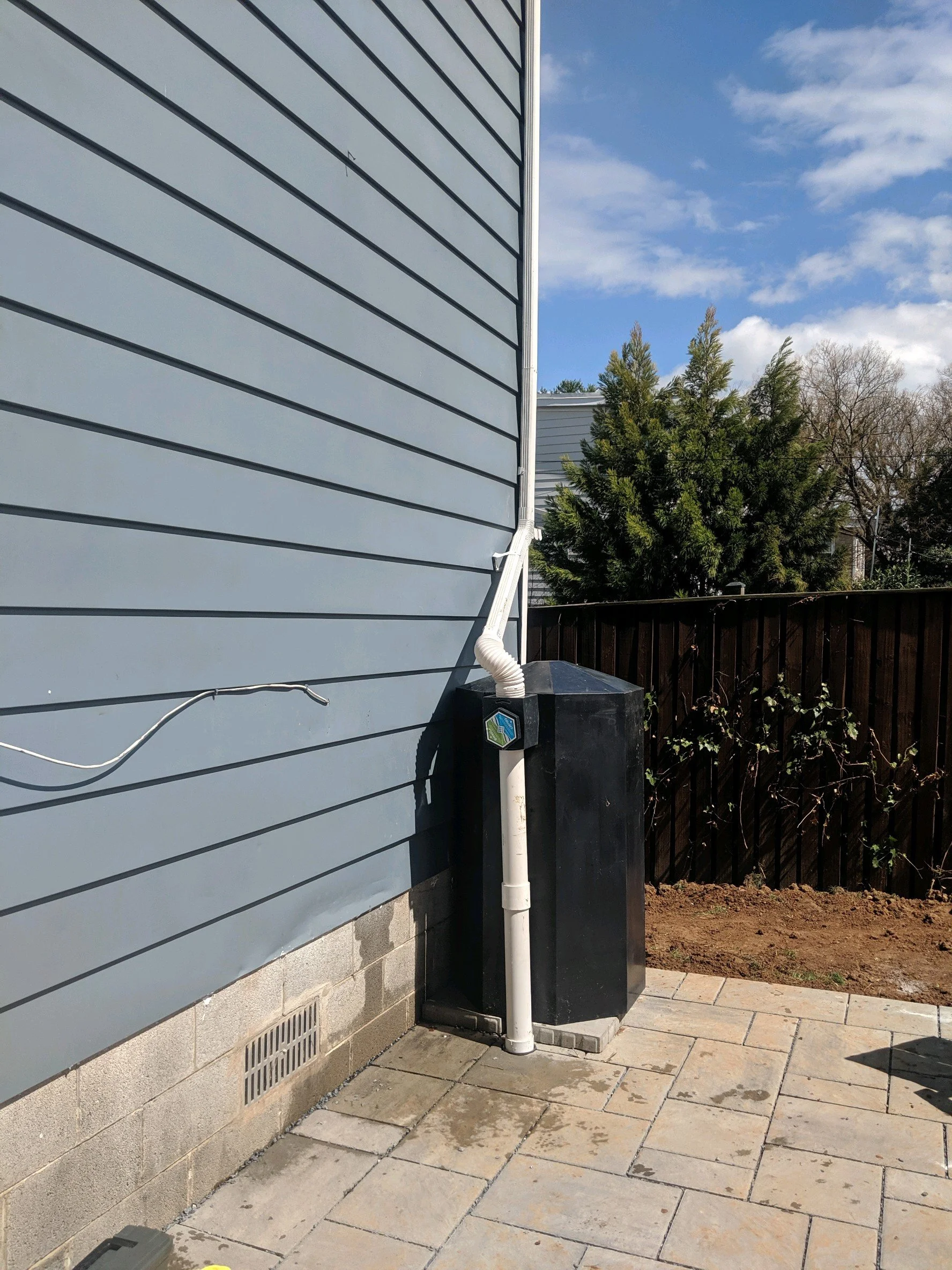 Downspout connection from rain barrel to permeable pavement
