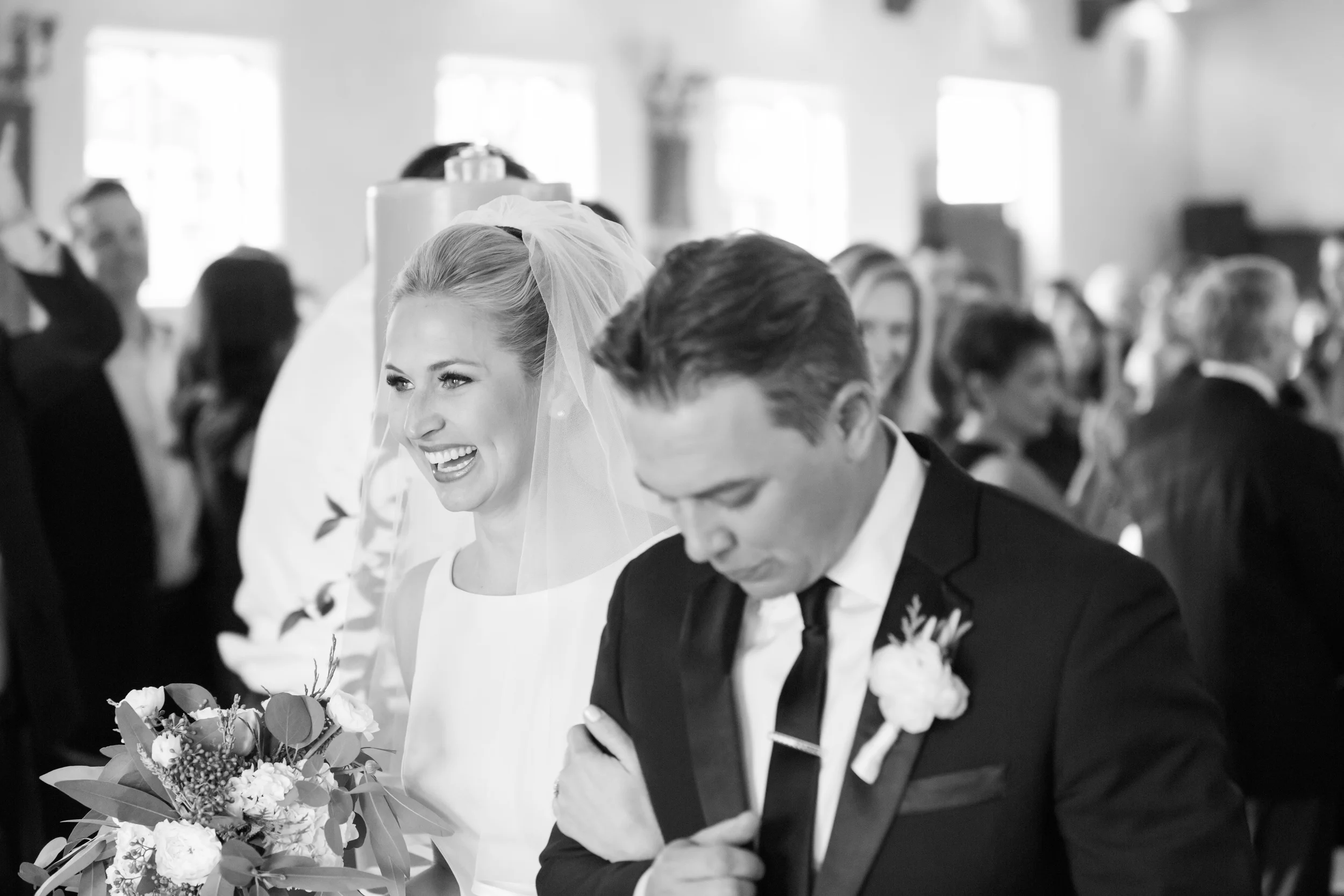 Bride and groom walking out of the church smiling