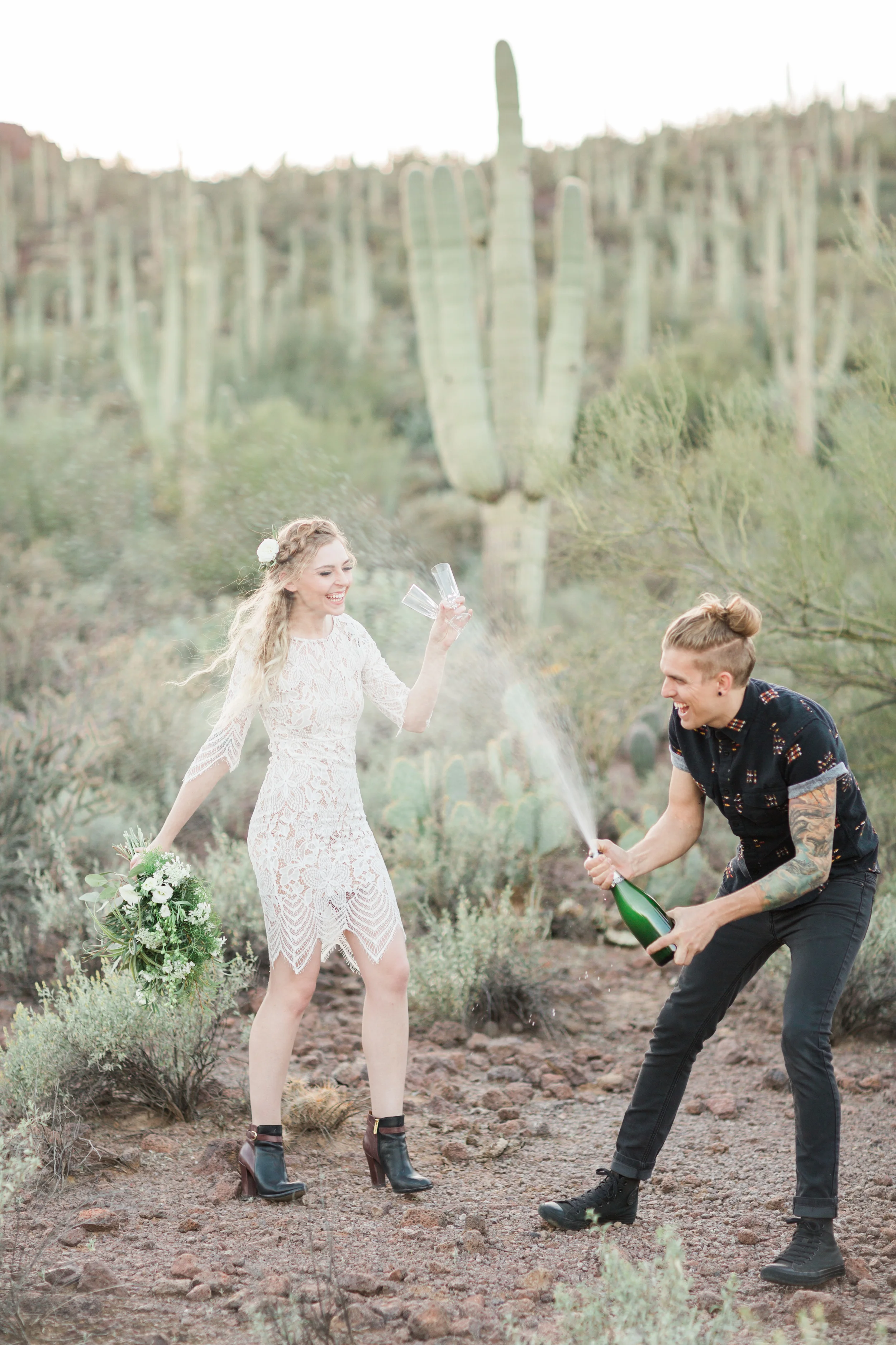 Husband and wife celebrating with champagne in the desert