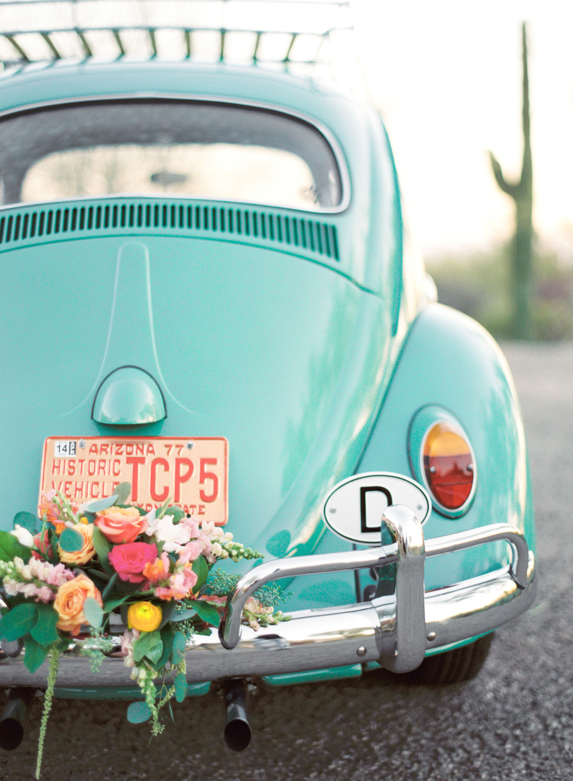 Adorable teal volkswagen beetle wedding car decorated with florals