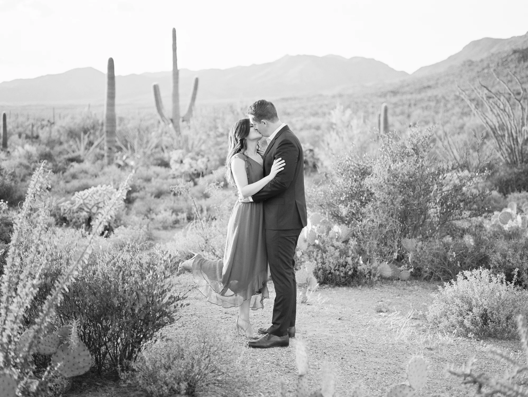 How sweet is this couple kissing in the desert?! This beautiful desert view is to die for and that leg pop is adorable. We love black and white photos, they are so romantic! 
