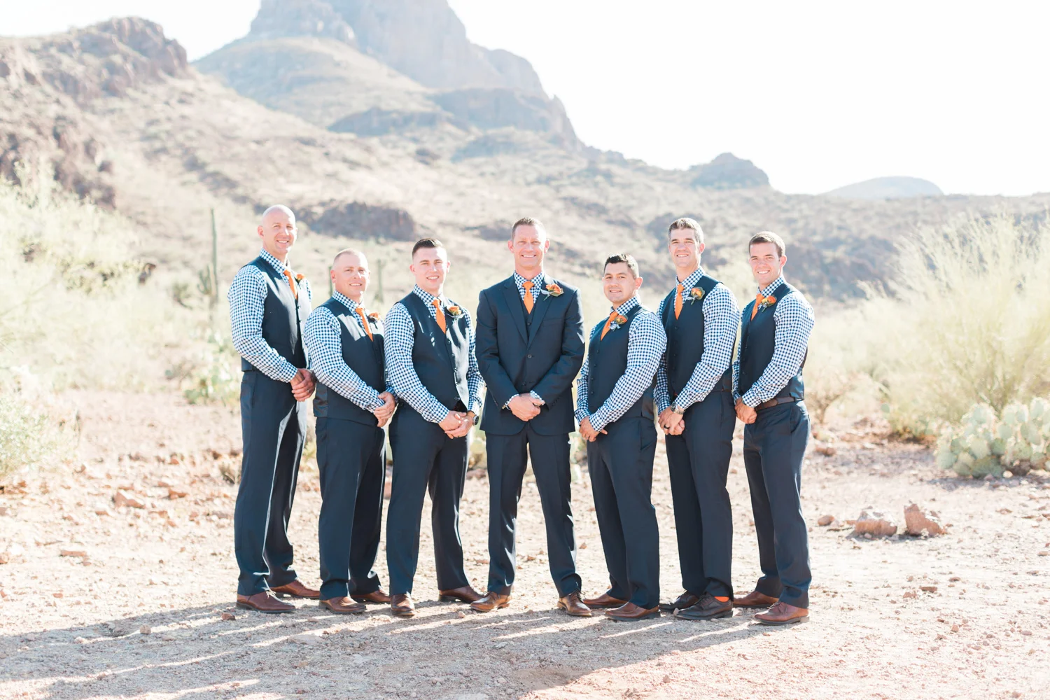 Handsome Groomsmen in navy gingham shirts with orange ties and navy suits. Beautiful mountain views in the background! 