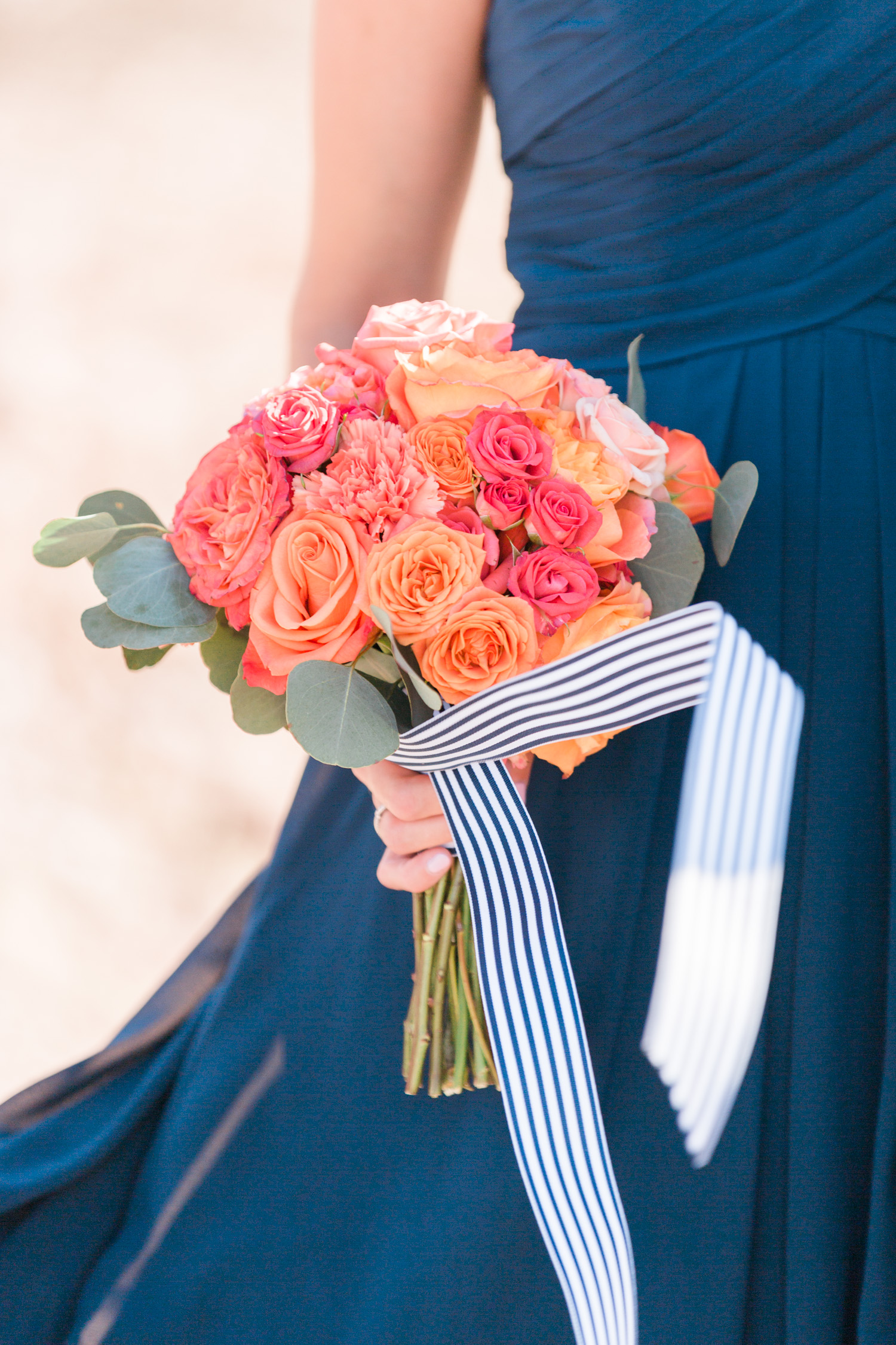 Beautiful salmon and pink bridesmaid bouquet with ribbon blowing in the wind. 