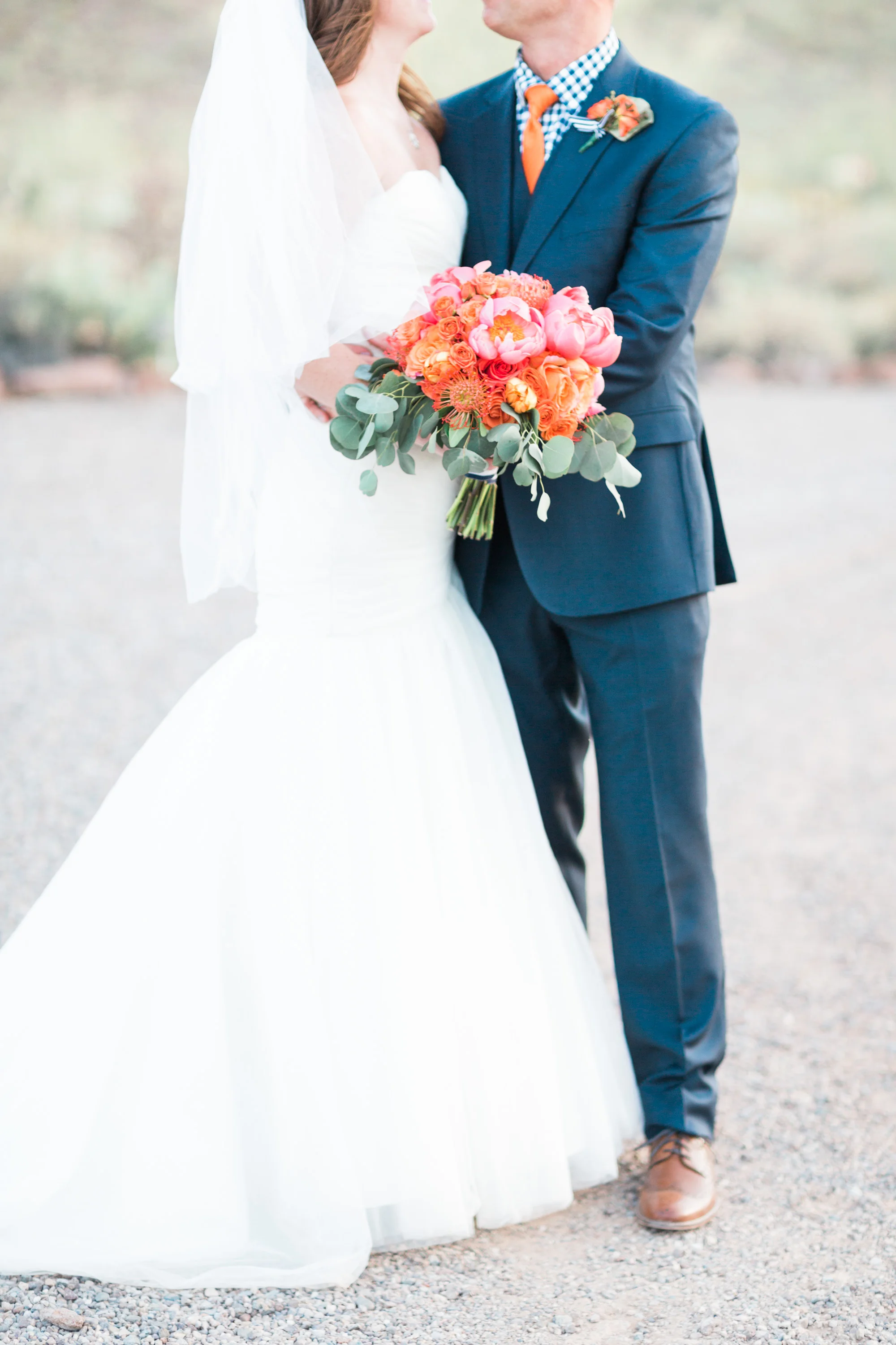 Bride and groom looking at each other lovingly. Bride holding her beautiful pink and salmon bouquet! 