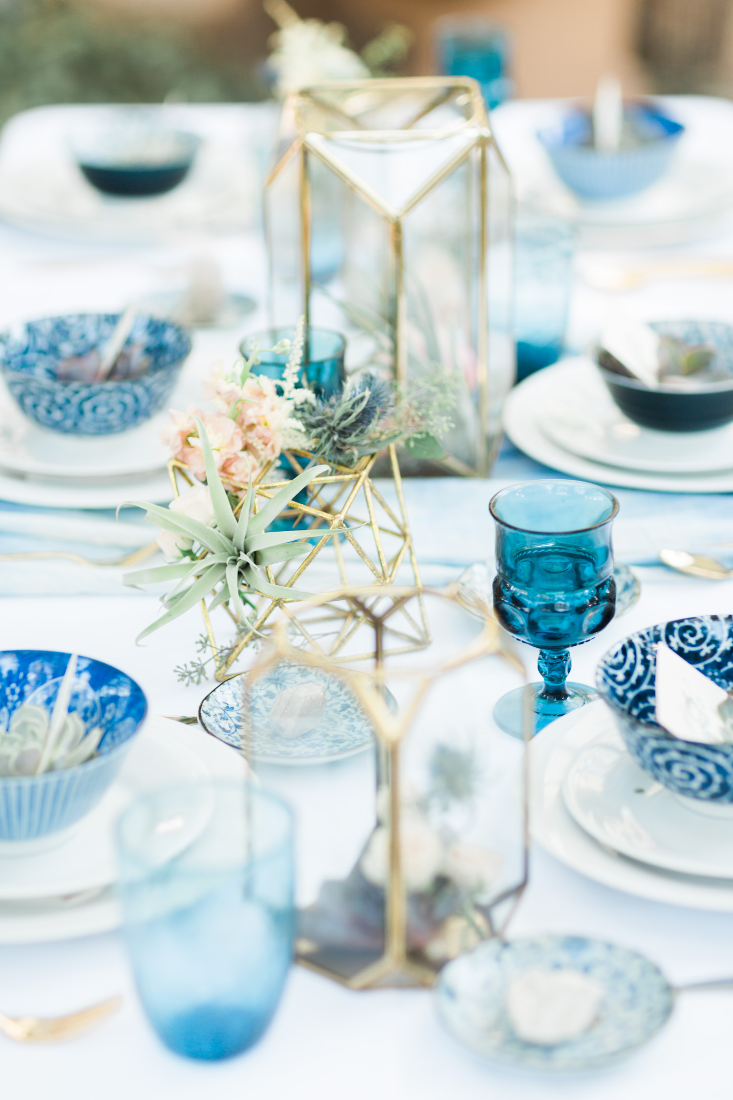 Indigo and gold tablescape with hints of blush florals and air plants