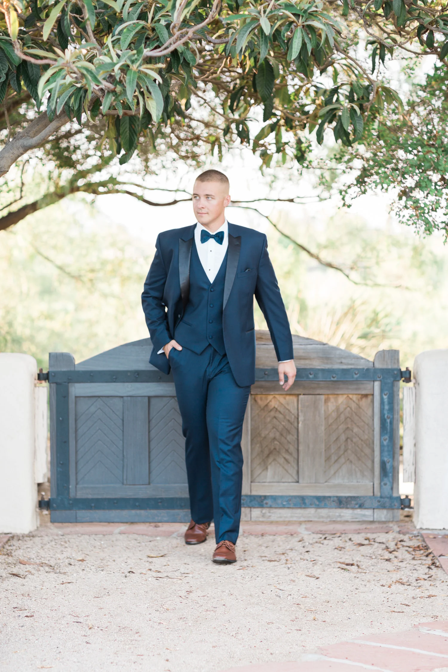 Handsome groom in a navy tux walking 