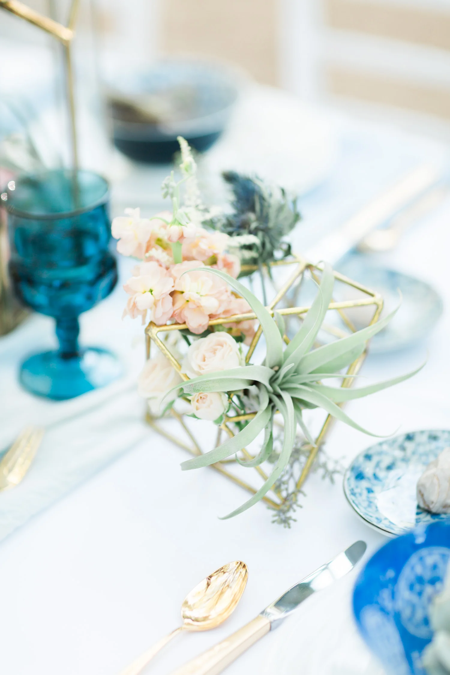 Gold and indigo table setting with air plants and gold flatware
