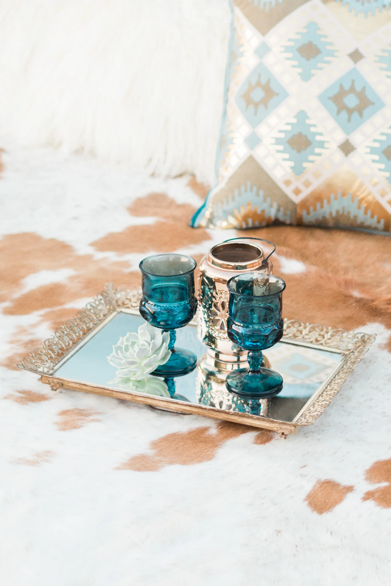 Blue antique goblets on a gold tray sitting on a cow hide rug