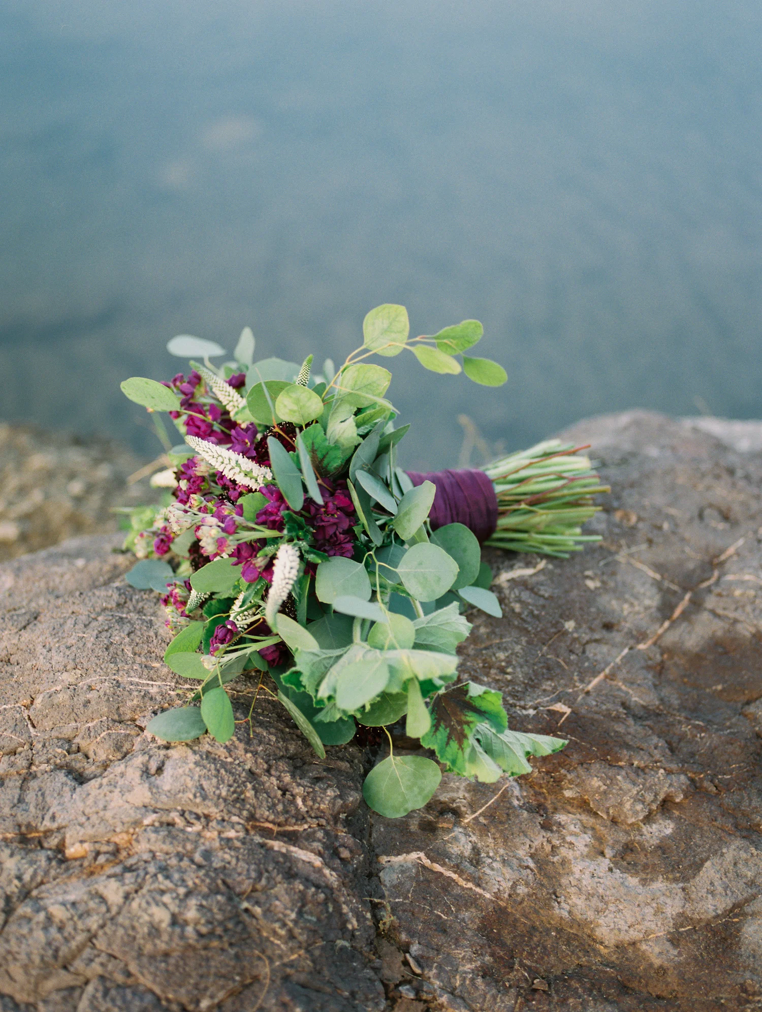 Stunning burgundy, purple bouquet by Phoenix florist, Butterfly Petals laying on a rock along the banks of the Salt River.