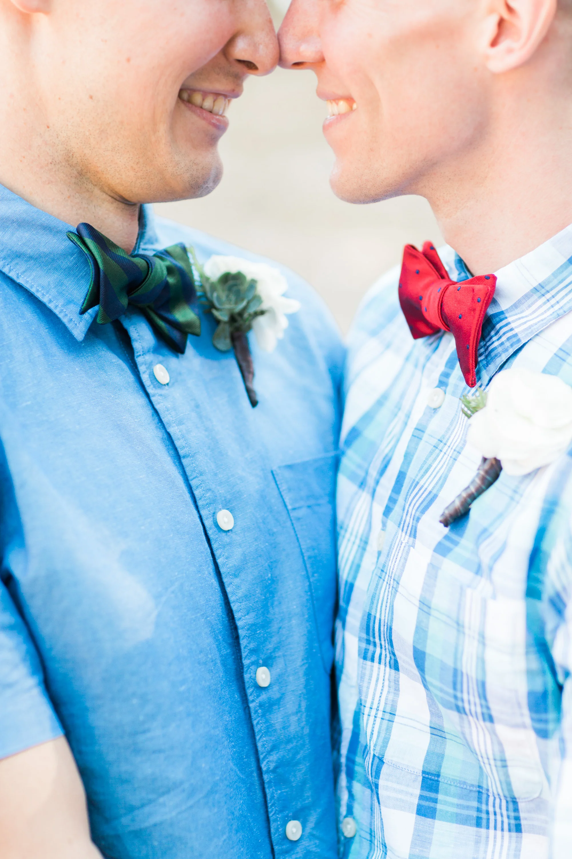 Casual Summer wedding, grooms in blue with fun bowties hugging on their wedding day