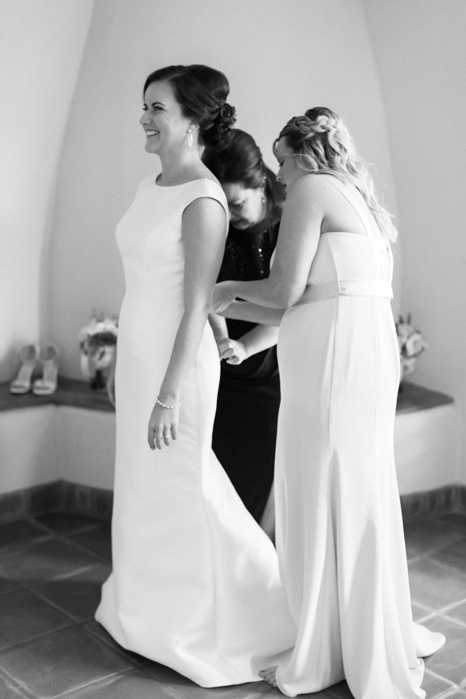 Bride's mother & sister buttoning up her wedding dress at the gorgeous Tubac Golf Resort.