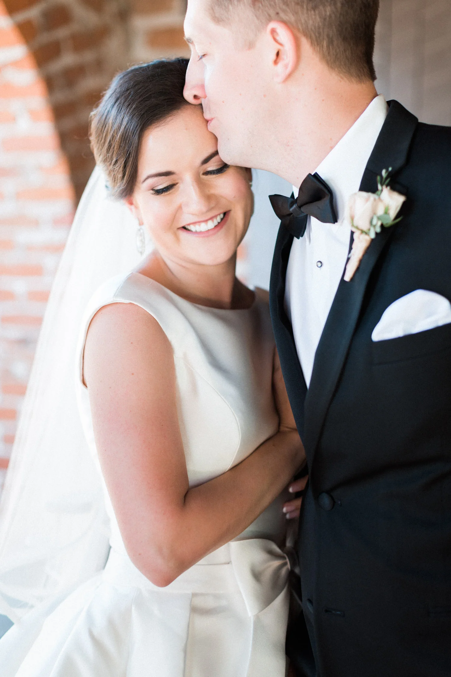 Bride smiling as groom kisses her on the forehead | Betsy & John Photography | Tucson Wedding Photographers 