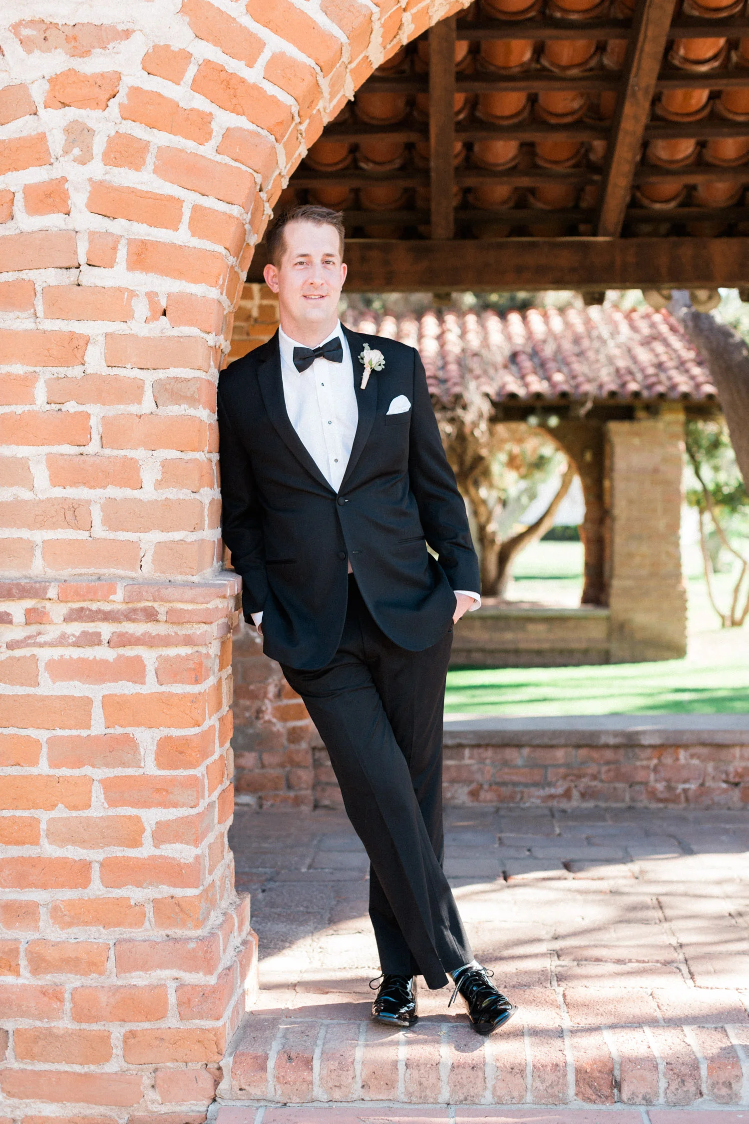 Groom leaning against wall