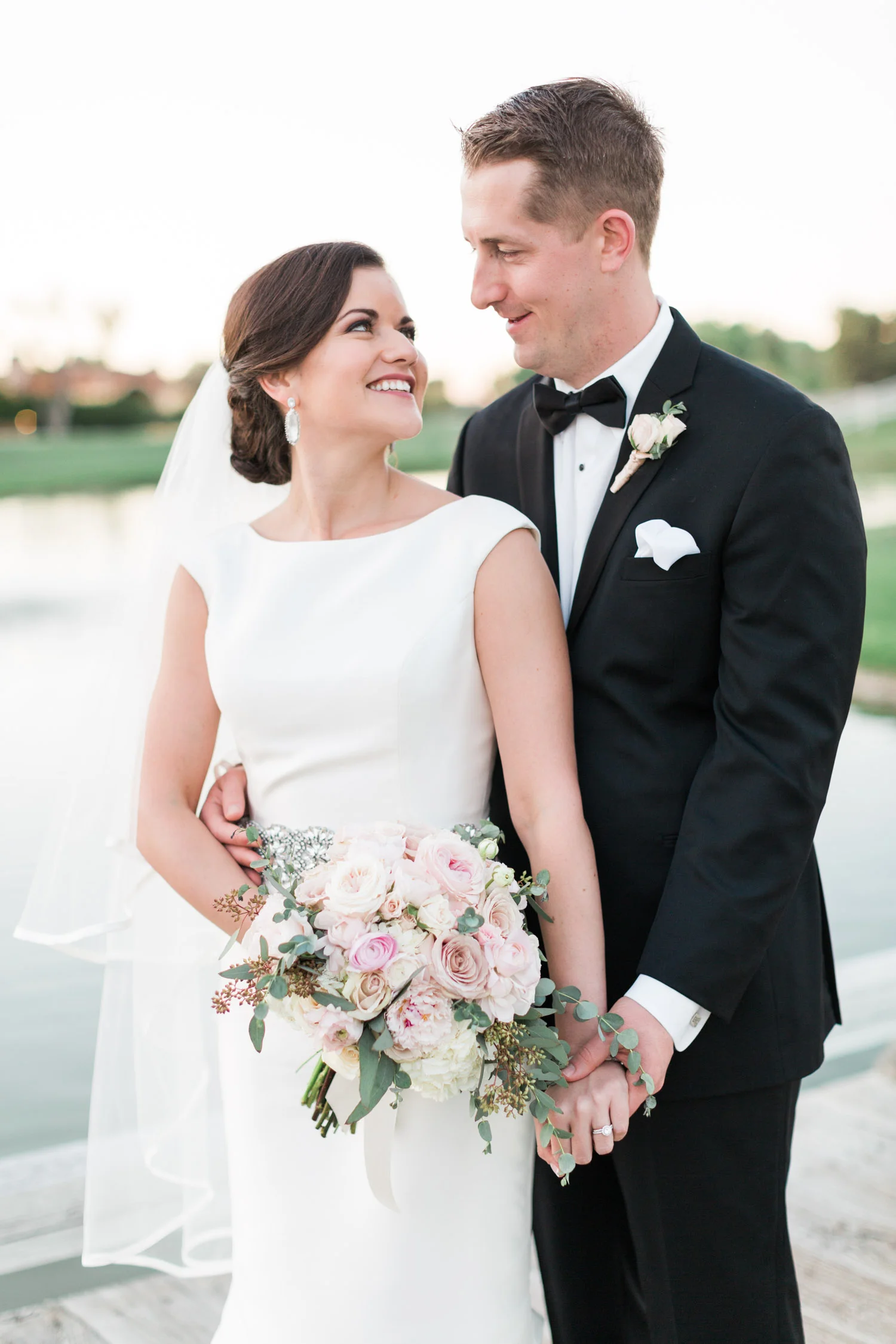 Bride and groom looking at each other and holding hands 