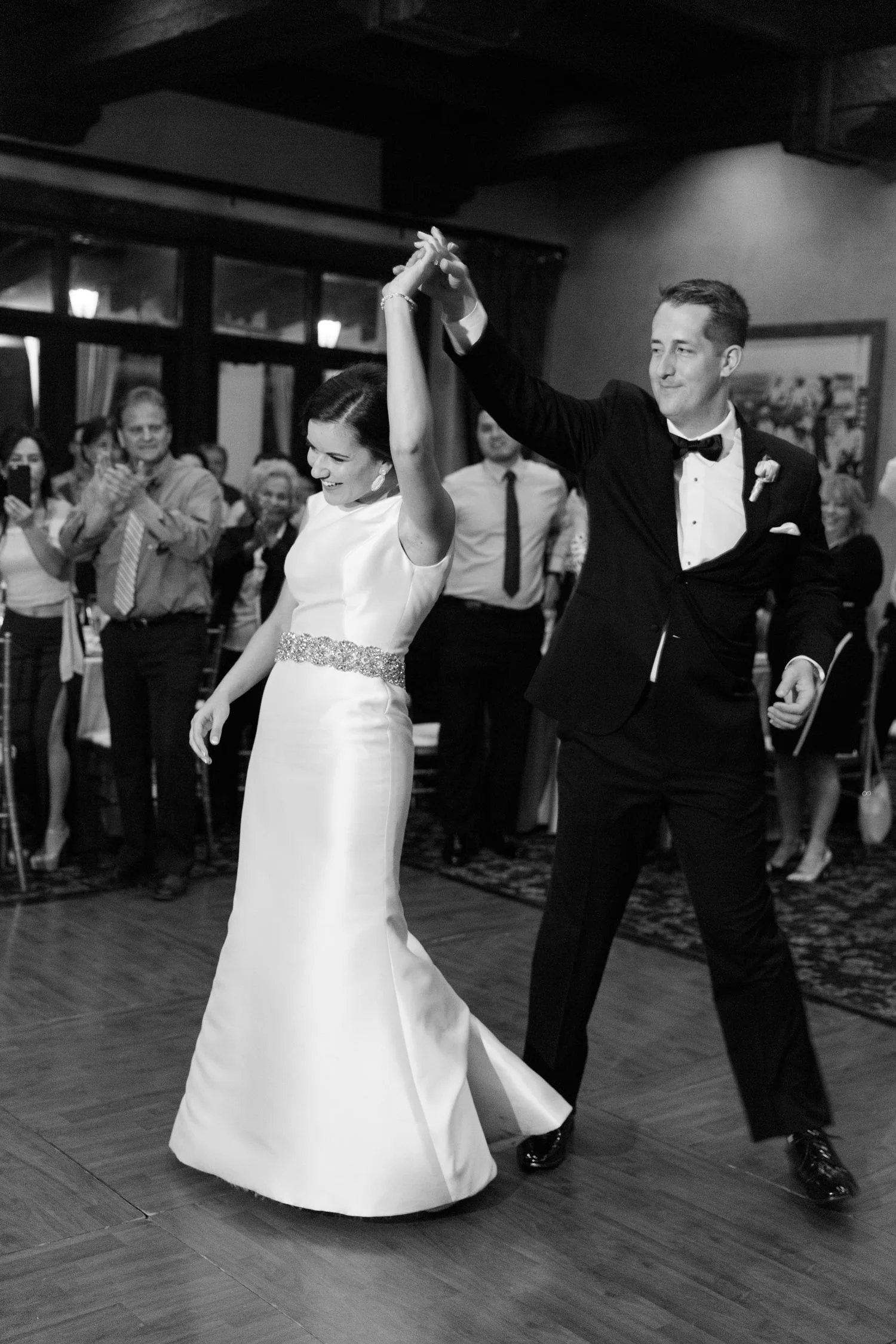 Groom spinning bride on the dancefloor during their first dance 