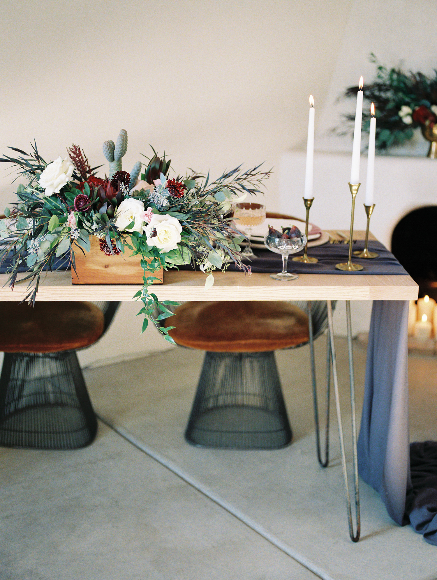 Hipster wedding reception set up with wild florals and tall candles in brass candlesticks