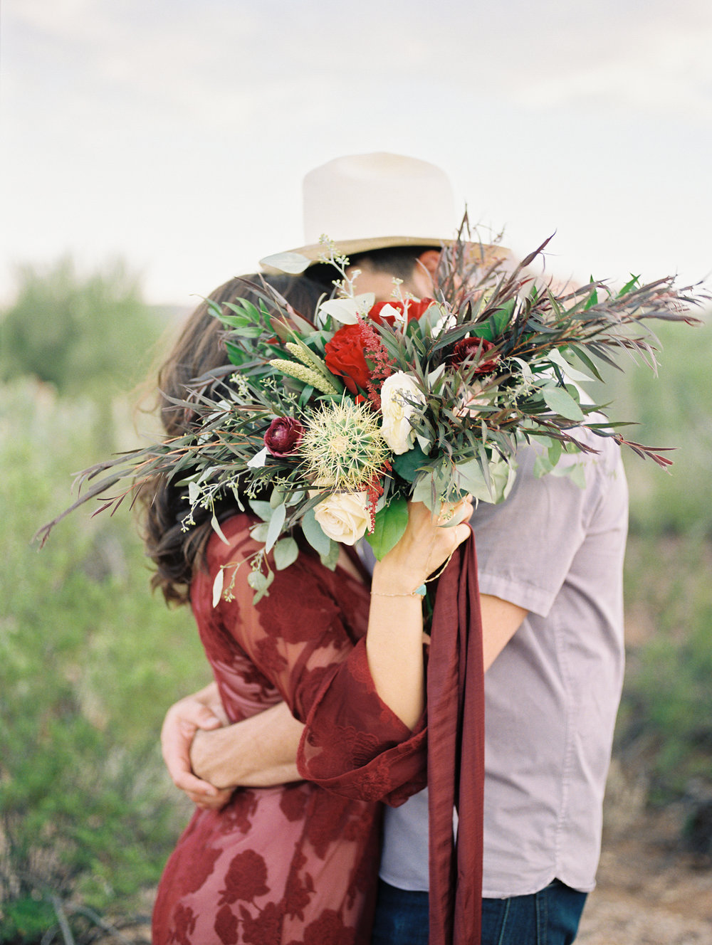  couple kissing, hiding behind beautiful fall bouquet. Such a cute shot by Tucson film wedding photographers Betsy &amp; John&nbsp; 