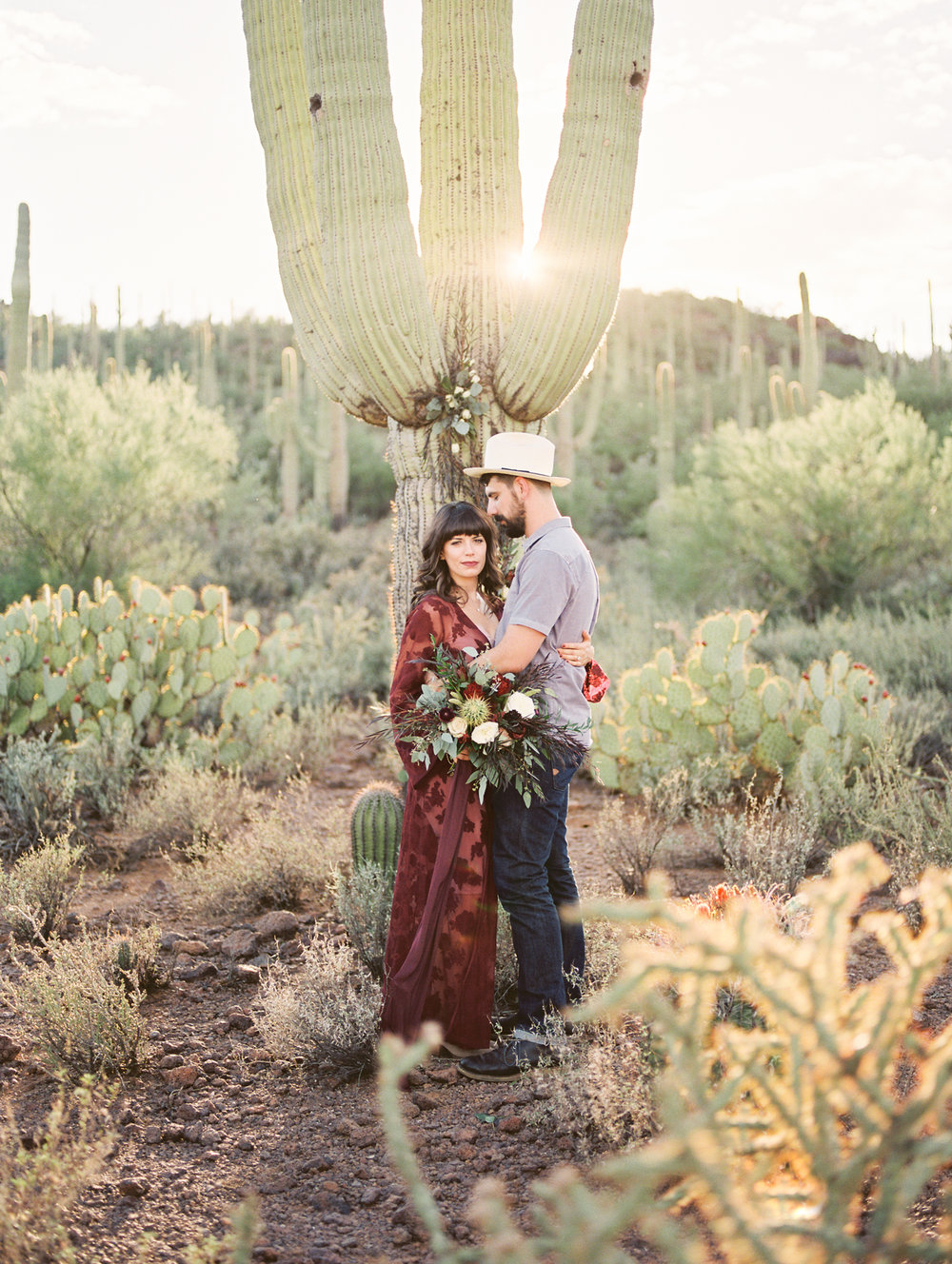  hip couple standing in front of a saguaro&nbsp; 