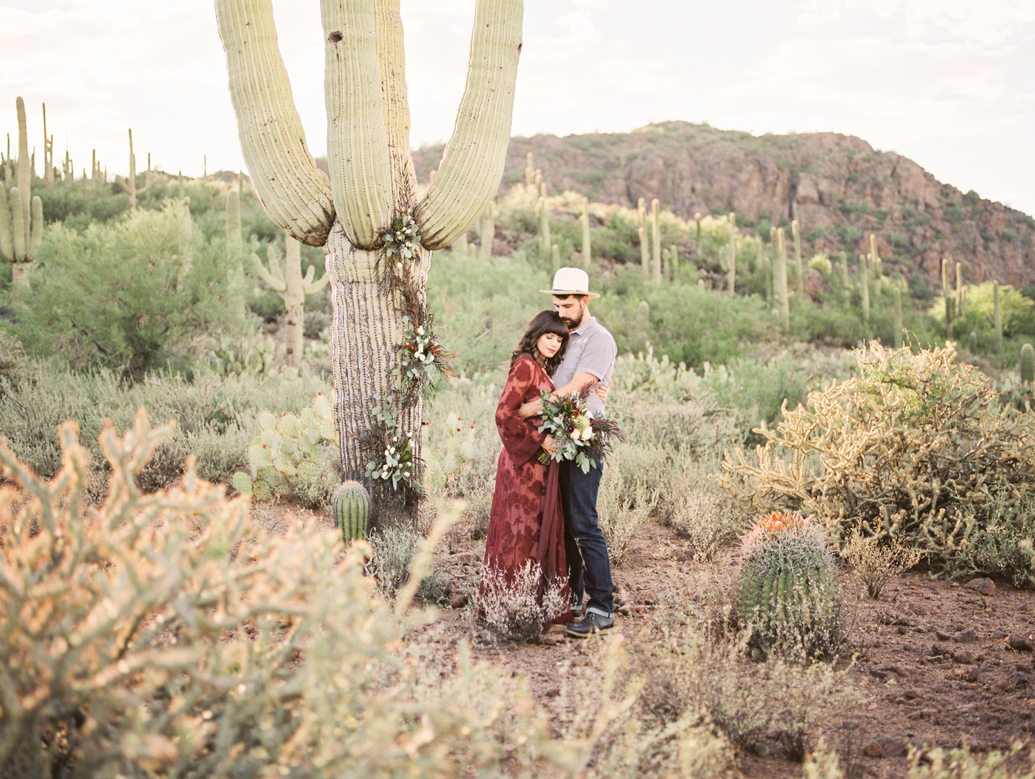 Couple in the Tucson desert with tons of saguaros in the background 