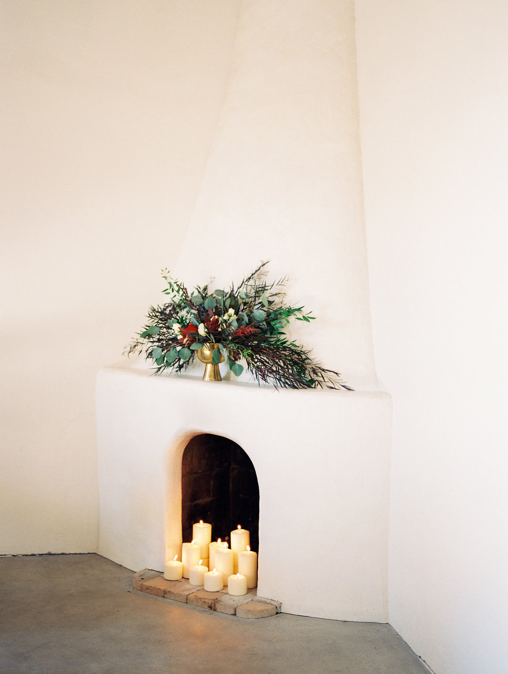  white beehive fireplace with candles burning and wild florals on the mantle&nbsp; 
