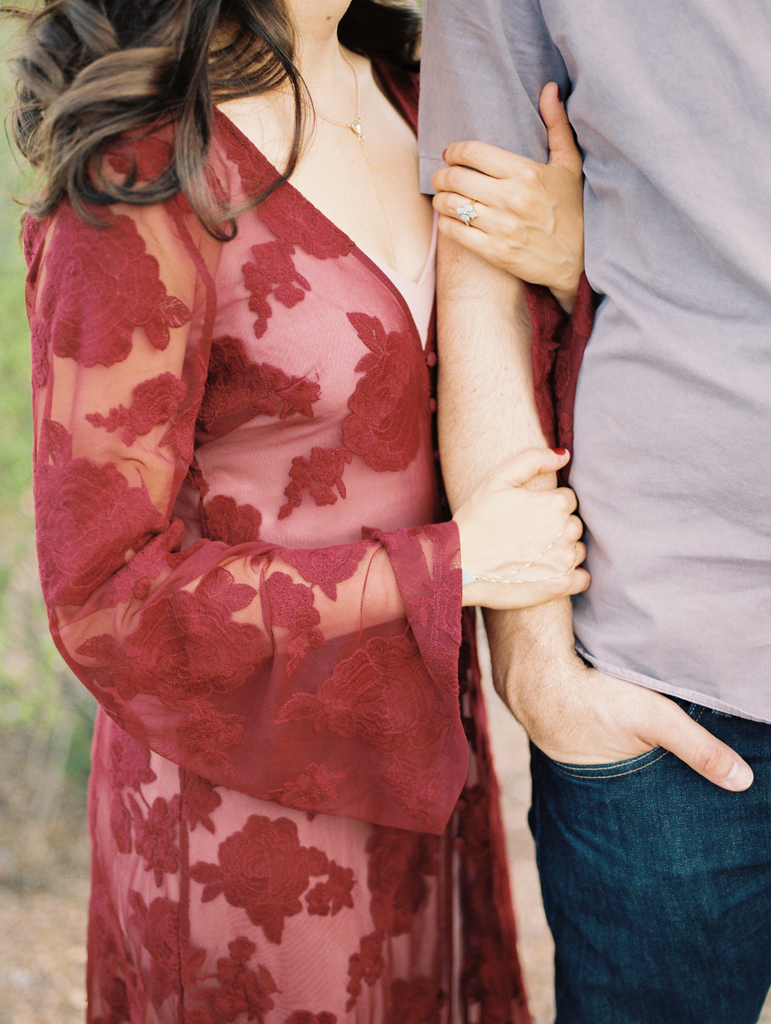 Bride in red dress holding grooms arm 