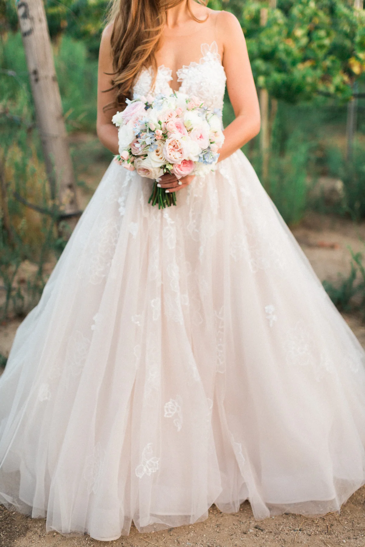 Gorgeous blush wedding gown by Essence of Australia with a blush bridal bouquet by Soiree Design & Events captured by Temecula wedding photographers Betsy & John 