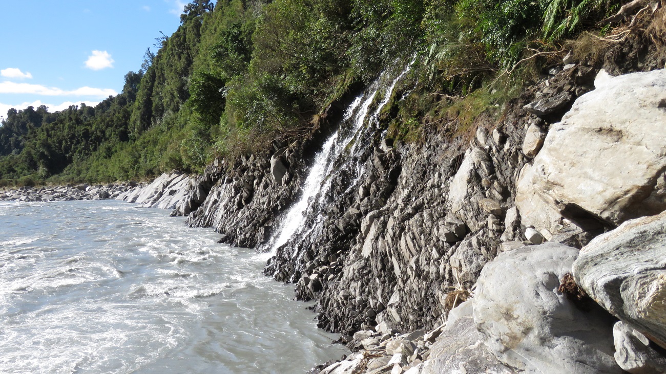 Flooding of the Waitaha had stripped the rocks back to a flat wall and sidling under this waterfall was too ugly with a heavy pack on, we decided to climb up and around this section through very tight scrub.
