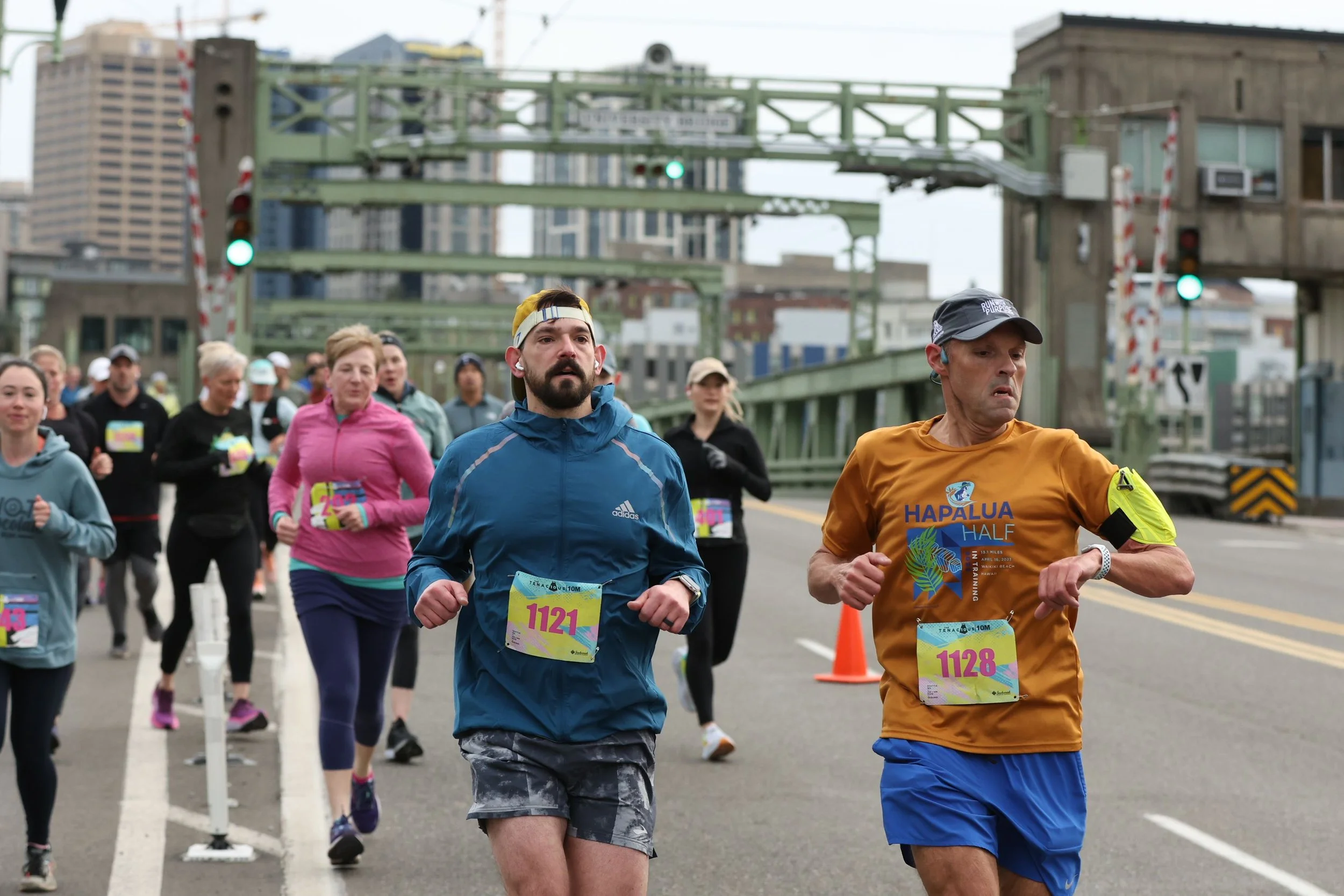 Runners passing the Space Needle and crossing Fremont Bridge during the Tenacious 10 race in Seattle