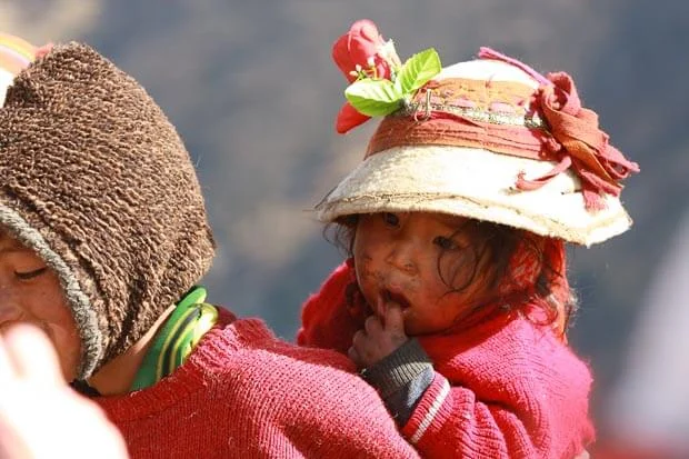 Young Peruvian Girl Gets A Piggy Back Wearing Traditional Clothing On The Inca Trail Peru