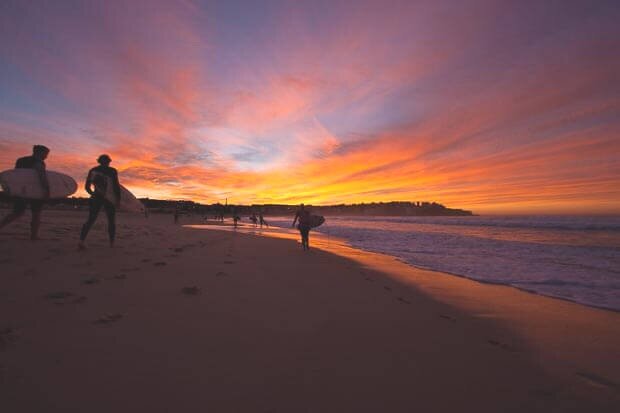 Surfers Walking Into Red Sunrise On Bondi Beach 