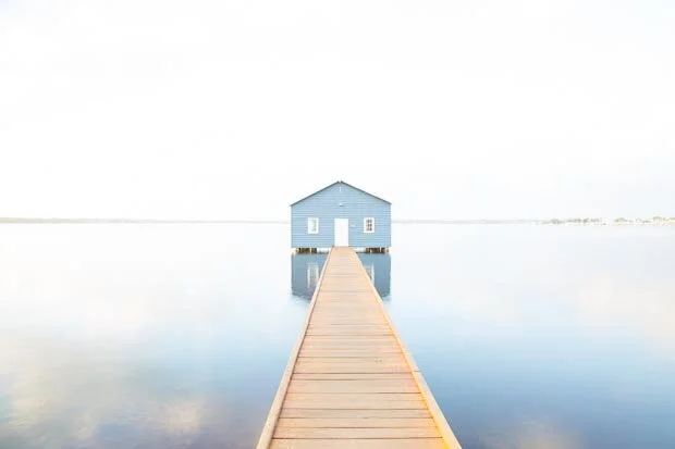 Reflections In Water Of The Blue Crawley Edge Boatshed At Sunrise