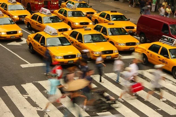 Pedestrians Cross In Front Of Many Yellow Taxi In Manhattan New York City