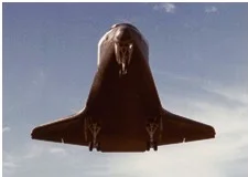 Space Shuttle Orbiter immediately before landing, showing landing gear deployed through heat shield (thermal protection system)