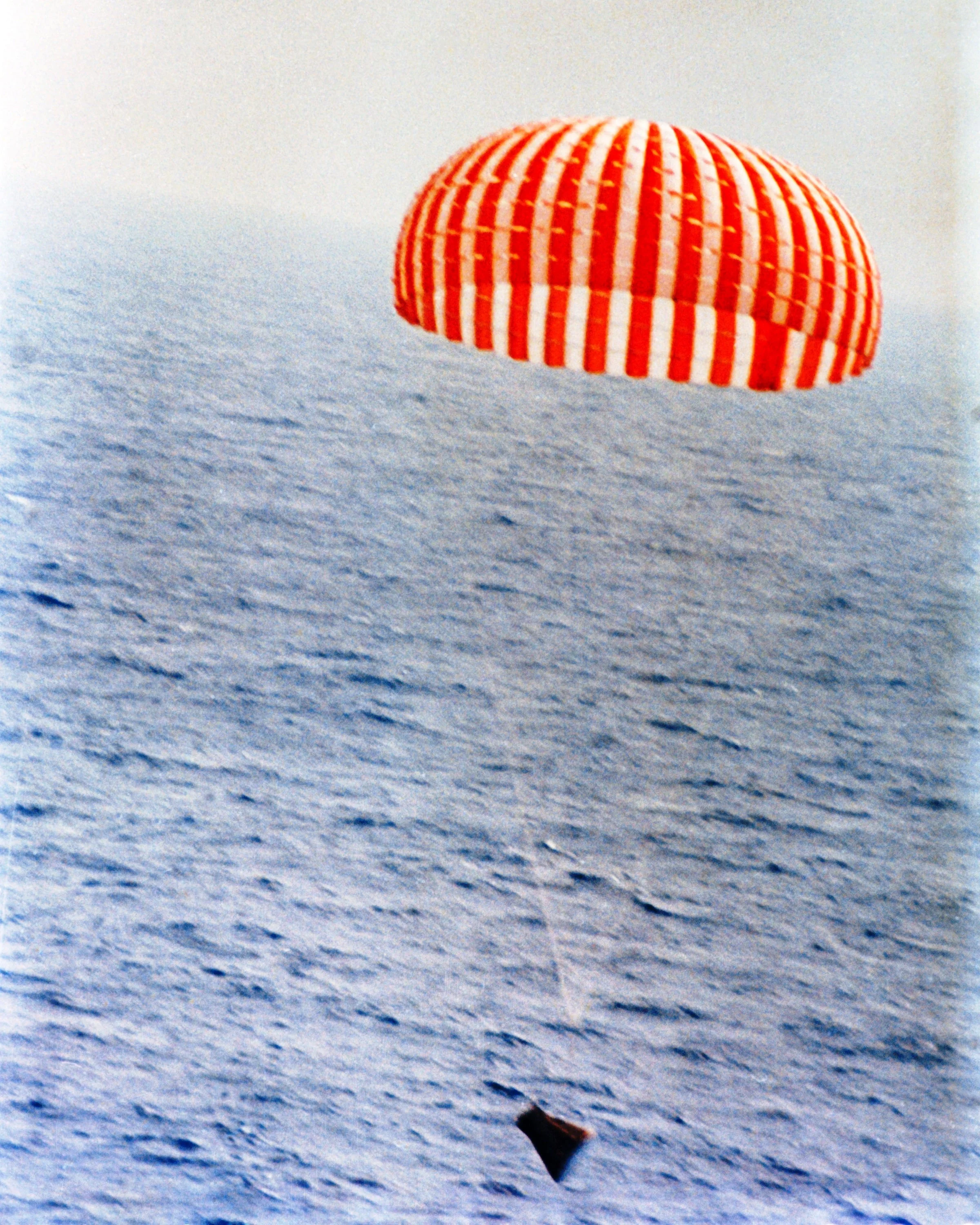 Gemini 9 nearing splashdown on June 6, 1966. Note the truncated nose and the high attach point of the parachute risers to the nearly-invisible bridle. (NASA Photo s66-34115.)
