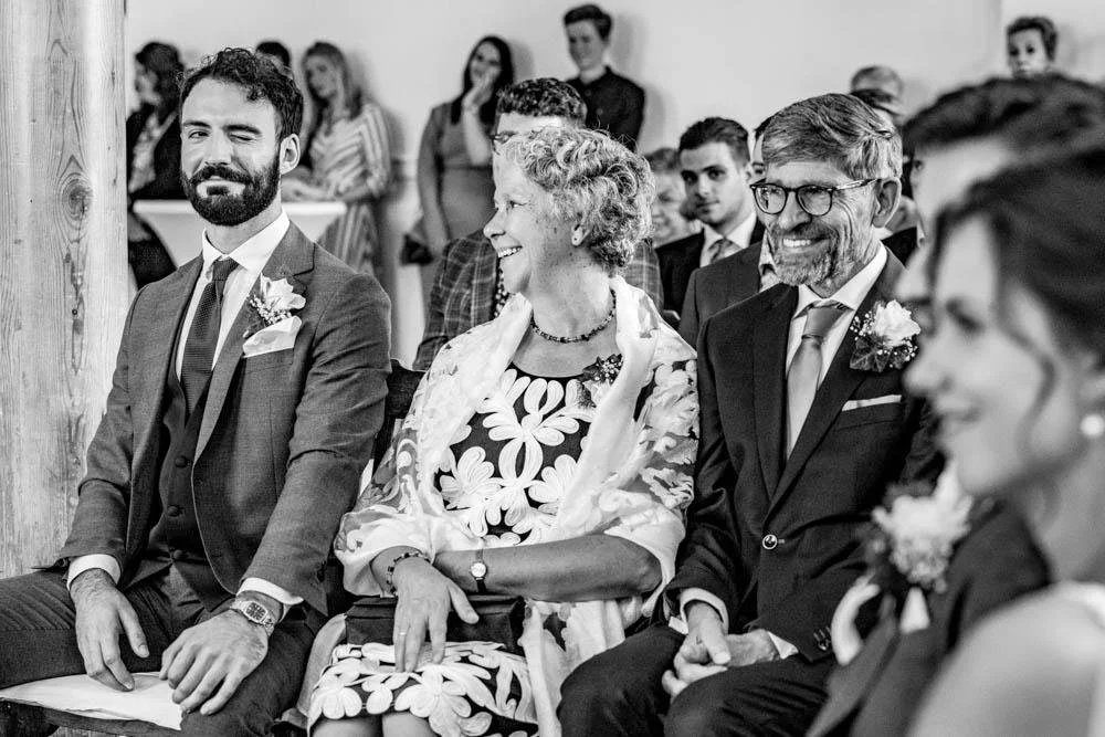 Een documentaire trouwfotograaf vangt dit kleine moment als een knipoog van de getuige naar de bruidegom op deze  bruiloft in rotterdam