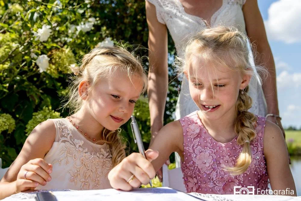 Bruiloft met bruidskinderen die de akte tekenen