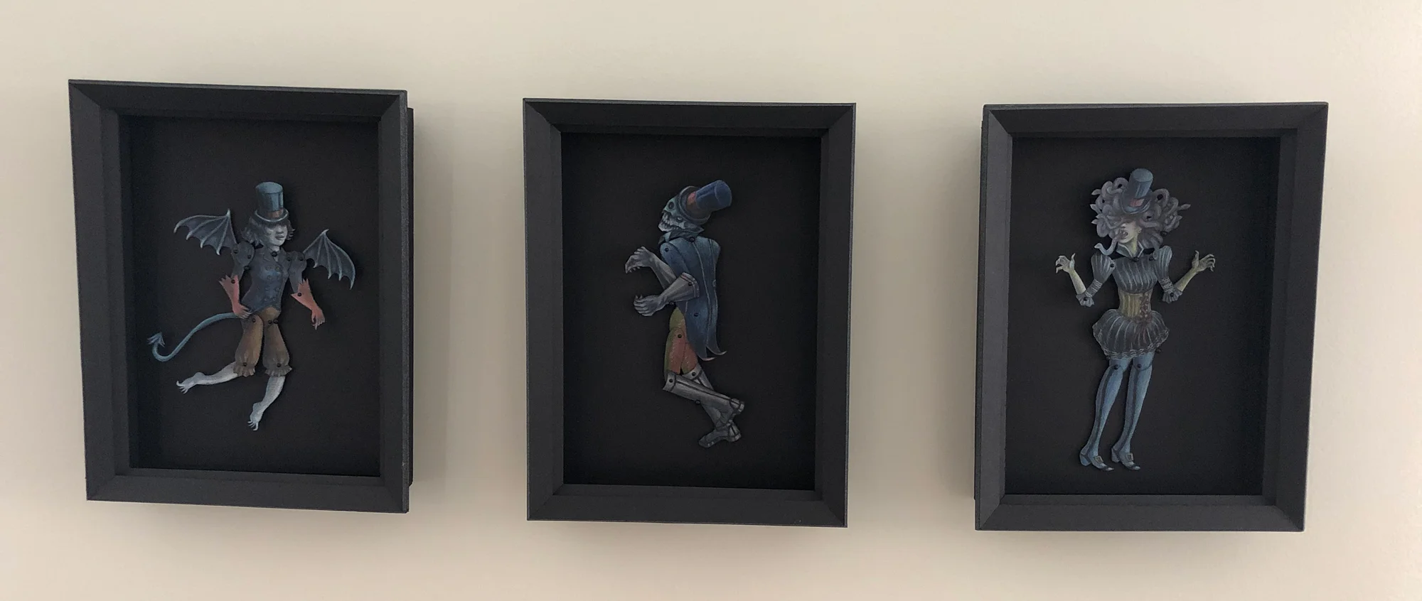 Each original paper puppet was created with colored pencil and has it’s own 9” x 11” homemade shadow box in which to live, move and play.