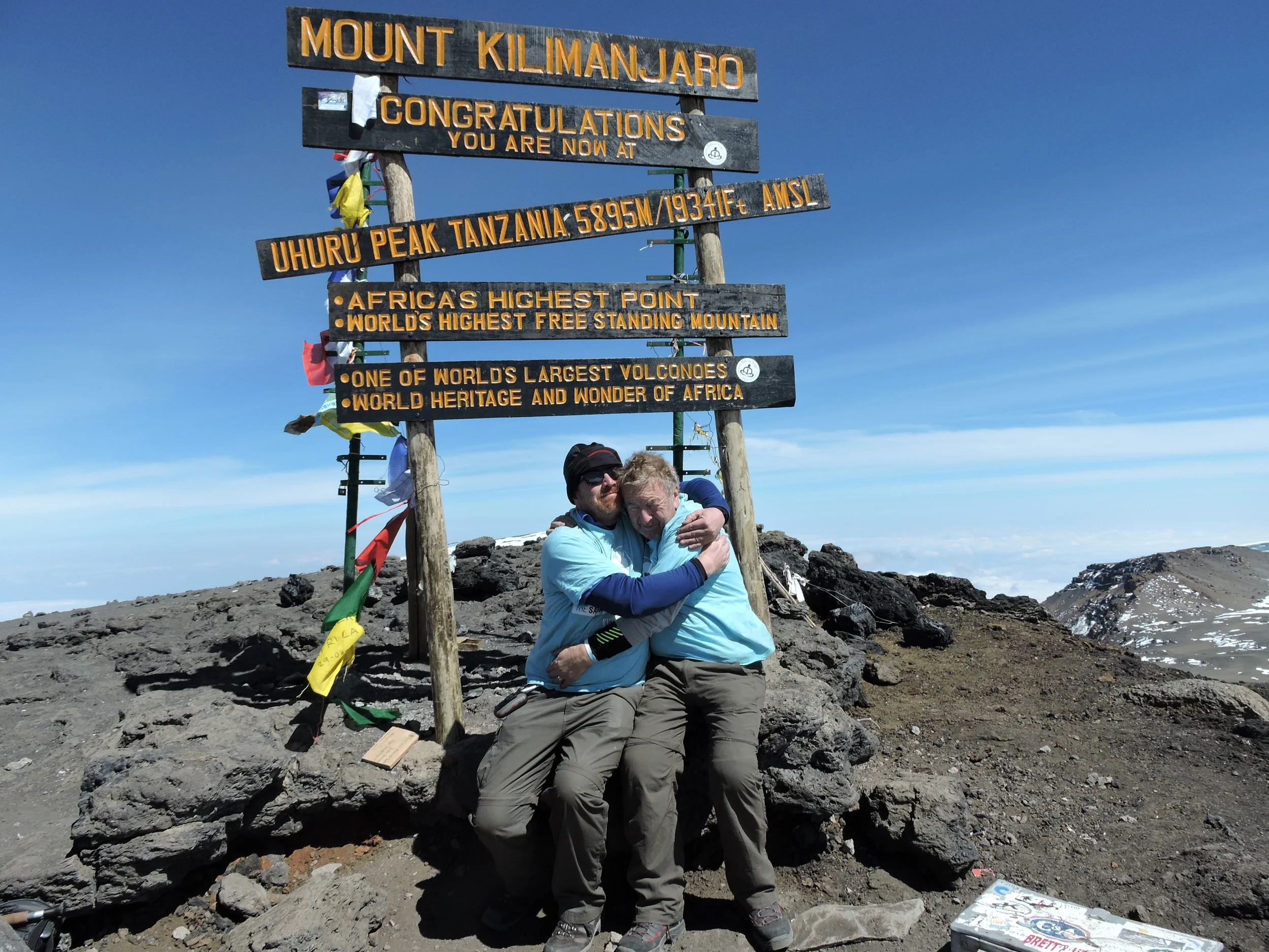 Sarah's father, Vic, and Sarah's half Brother, Simon, embrace at Uhuru Peak, the summit of Mount Kilimanjaro. A highly emotional occasion for them both.