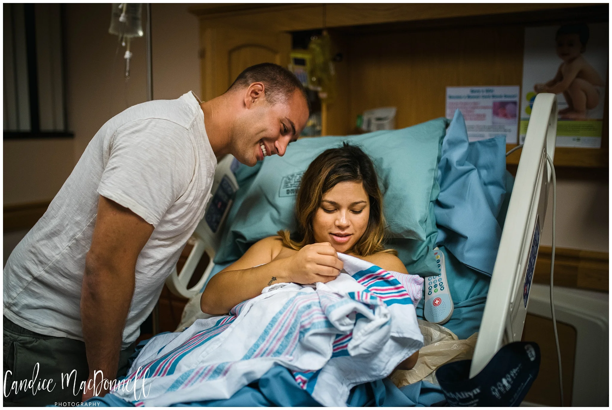 parents cuddling with newborn shortly after birth, missouri birth photography