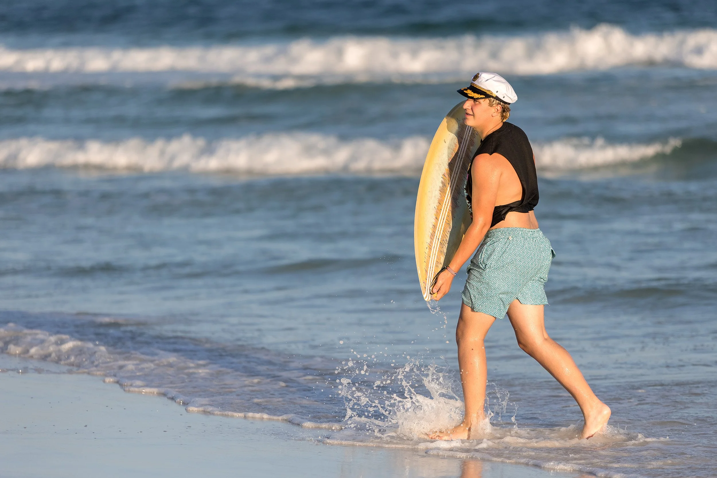 Boy carrying a skimboard on a 30A beach