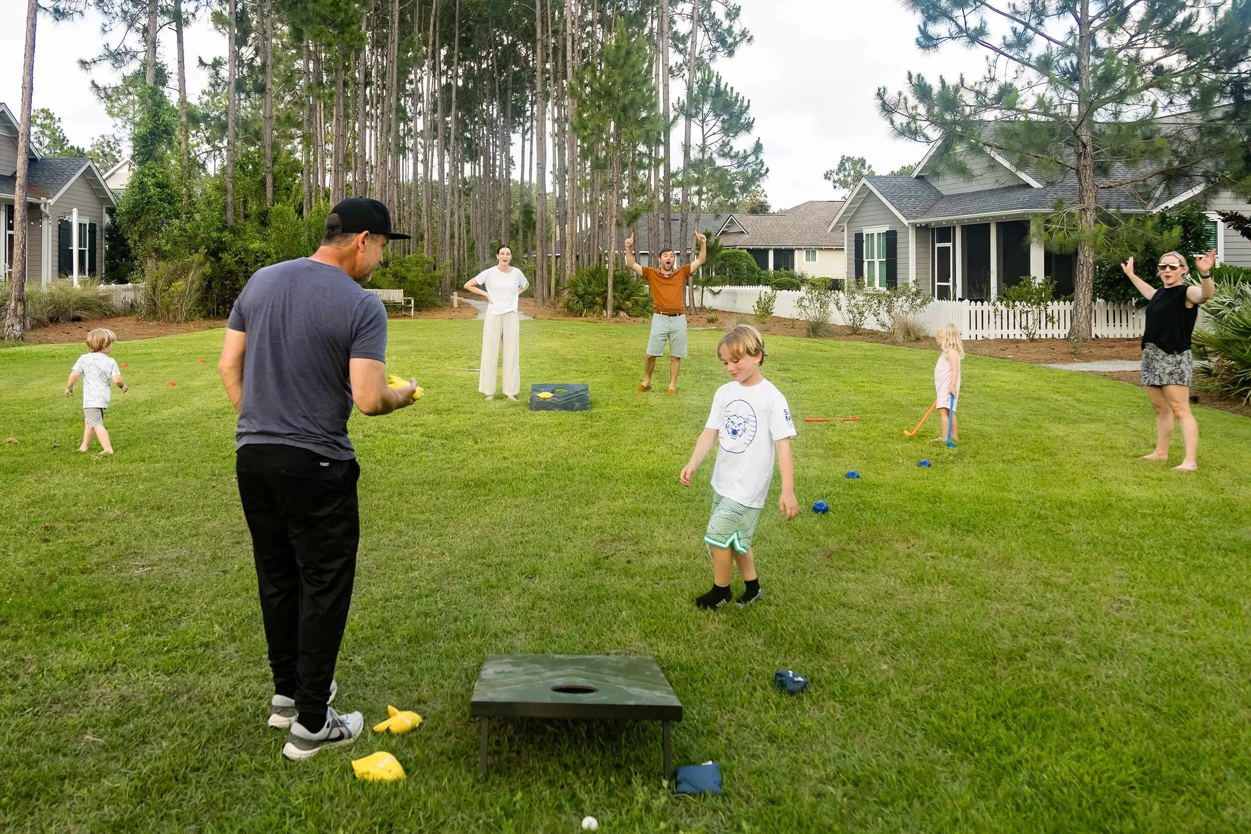 Unposed family photography session of family playing corn hole on 30A