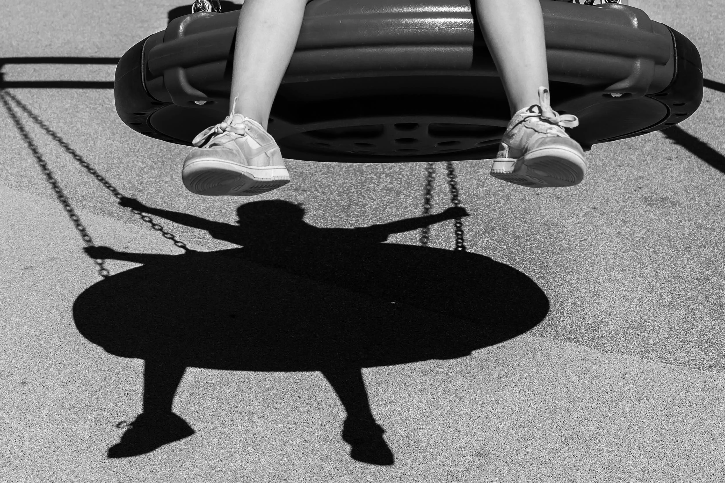 Shadow of little kid swinging at Camp Creek during candid photo session