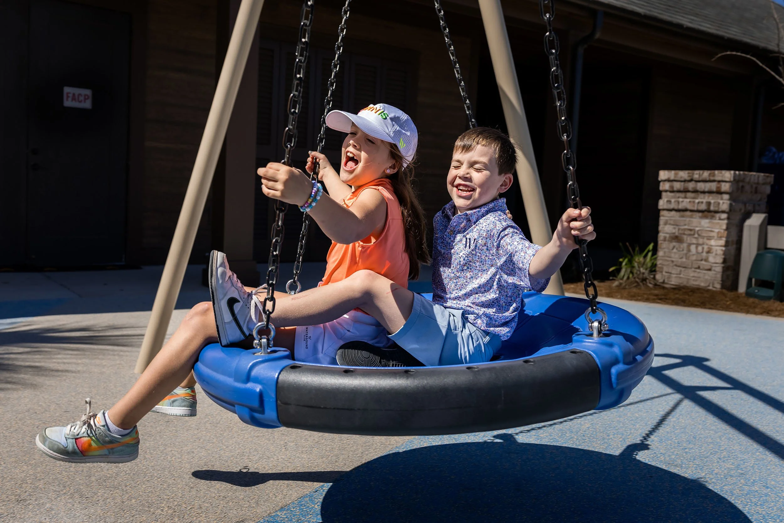 kids playing on a swing during a relaxed family beach photo session on 30A in Florida.