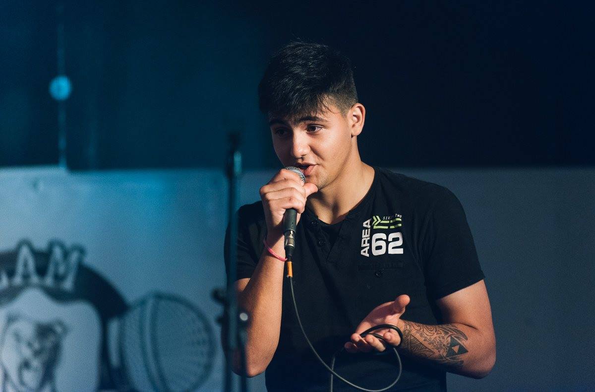 Aljaž Šešo a.k.a Spanky Kljub trdno zakoreninjenemu slovenskemu poreklu, ga mnogi ne opredelijo kot takšnnega. Je posebne sorte človek, saj ni ne moškega ne ženskega spola, vendar je Apache. V glavi ima možgančke, ki ne delujejo kot normalni možgani, saj so le ti na počitnicah 333 dni v letu. Večino svojega prostega časa preživi z igranjem 'brutalnih' video igric, kadar pa ne sedi za računalnikom pa se ga najverjetneje da najti v lokalni gostilni. Redni gost (vstavi poljubno multinacionalko). Fant, ki je tako hardcore, da joka med romantičnimi filmi #trueGangstaShit . Živi v svojem svetu, v bistvu, če smo natančni, živi pri starših. Je neustrašen študent, ki zmeraj plačuje za 'rekreativne dodatke', tudi če so mu podarjeni preko 'družbenih običajev pitja in prehranjevanja'. Pravi poštenjak! To je človek, ki hodi po svetu in išče svojo sorodno dušo, do takrat pa ma dve zdravi roki (Lefty & Righty with Spanky the Almighty). Navdušenec nad znanstveno fantastiko, stand-up komedijo in poezijo – področja, ki jih tudi v svojih 'delih' združuje v eno. Ko smo ga vprašali zakaj piše pesmi, je rekel, da zato, ker ima čas. Vedno si vzame veliko časa preden odgovori na kakšno vprašanje. Zelo rad ogovarja druge in se često trudi nepravilno uporabljati slovnico, samo zato, da razjezi kakšnega slavista. Foto: Gregor Salobir