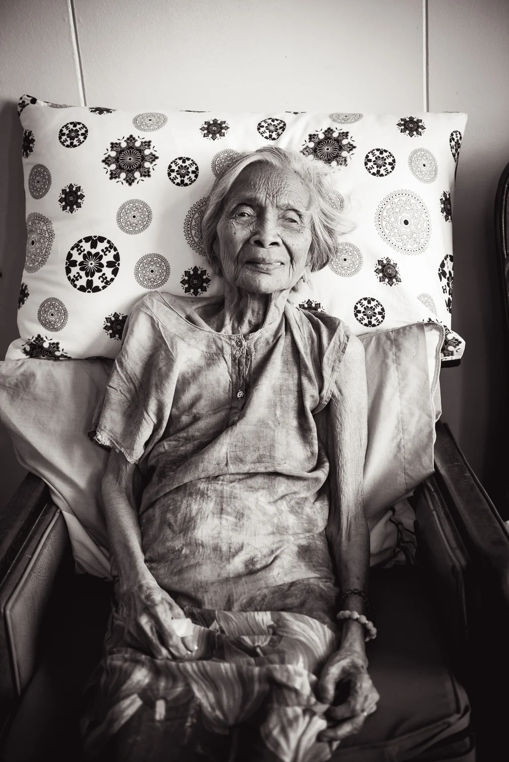 A trip to the Philippines would not be complete without a visit to my Lola (Grandmother on my dad's side). To visit her, we must leave the chaos of Manila and make our way towards the smaller town of Guagua in the Pampanga Region. Usually, a visit to my Lola's house includes a family meal complete with many Pampangan delicacies like chicharon bulaklak (Deep fried pork intestines) and betute tugak (stuffed frogs). In past visits, we sometimes were treated to my Lola's enduring piano mastery despite her age and lack of mobility. Due to our trip schedule and family reunion, our visit to my Lola was shorter this year. She remained sitting in the chair beside her bed as we all exchanged greetings. Because of the distance and difficulty of travel for my Lola, I've only seen her a handful of times in my life. I'm glad I got to see her this past year and wanted to make sure to take a good photograph of her. In 2017, she will be turning 99 years old.