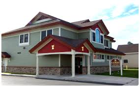 Photo of a grey and red pharmacy building that looks like a residential house, with a street-level entrance