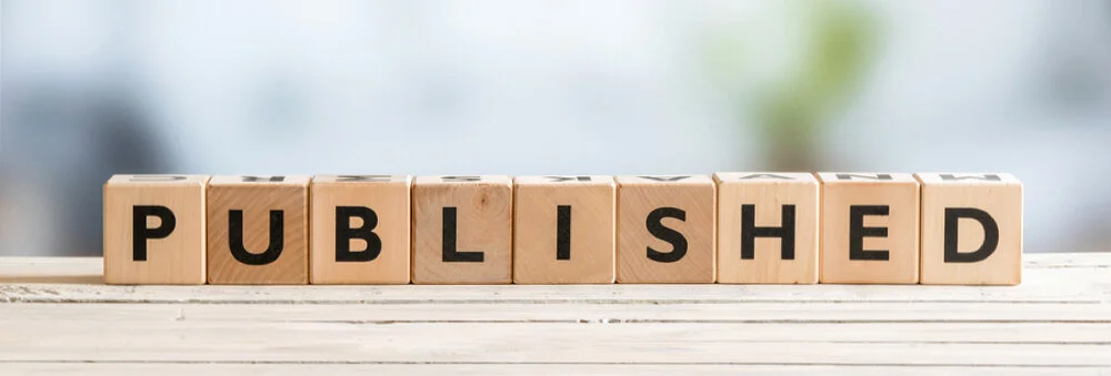 The word PUBLISHED spelled out in a line of wood letter cubes