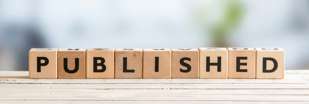 The word “PUBLISHED” spelled out on wooden letter cubes