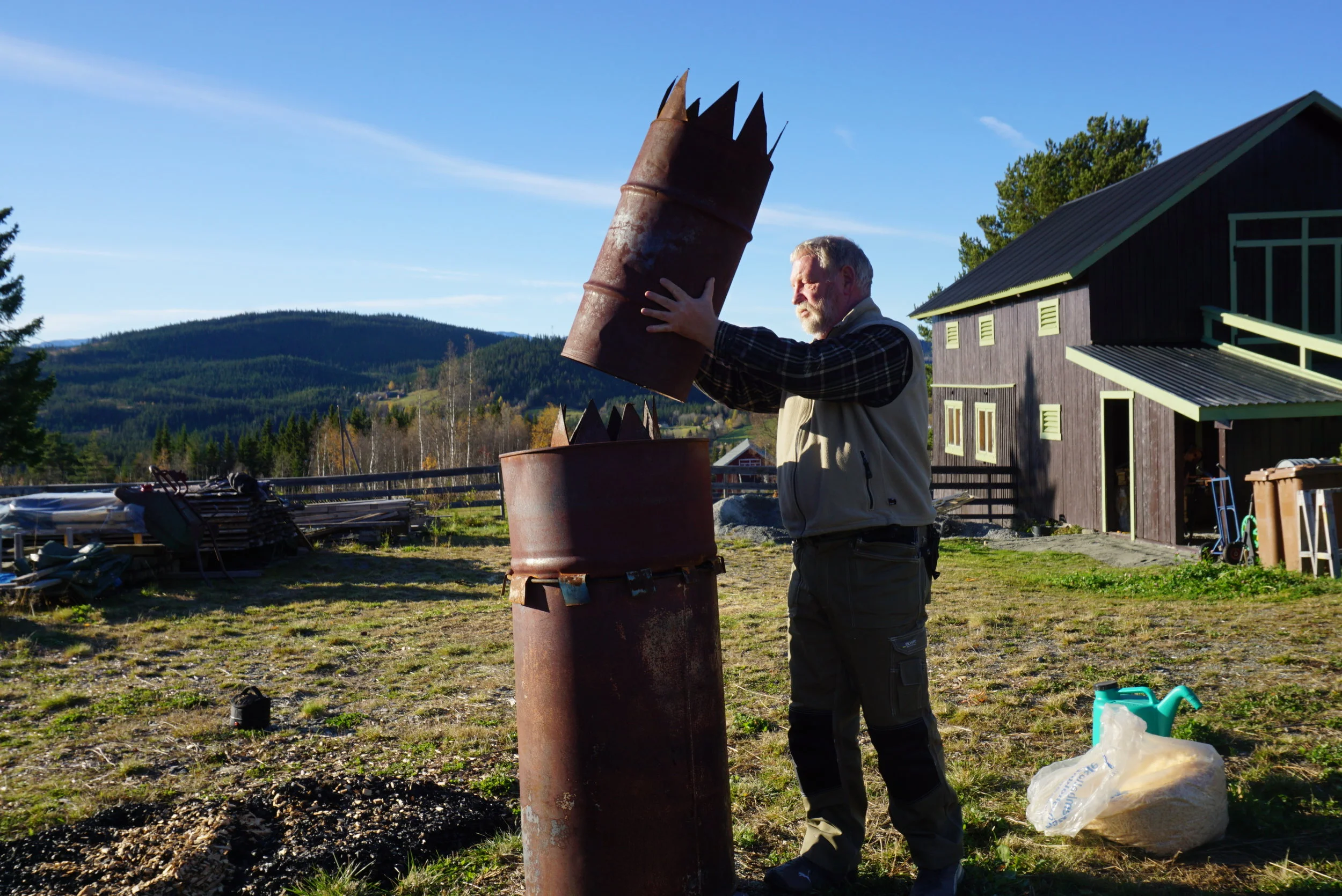 Gamle oljefat i miljøtjeneste. Like enkelt som det er genialt. Gjennom utallige runder med prøving og feiling har de funnet balansepunktet for den optimale kullbrenningen.